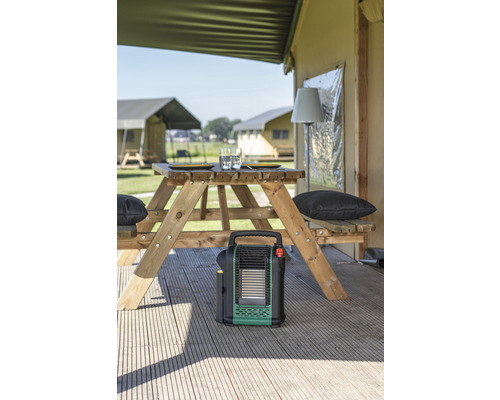 Scene met tafel en banken, verwarming en tenten op de achtergrond