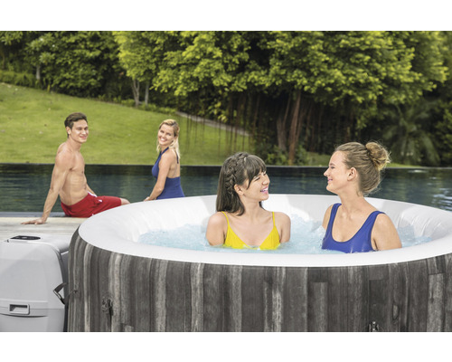 Opblaasbare hot tub met mensen in de tuin