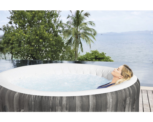 Vrouw ontspant in opblaasbare whirlpool met uitzicht op zee