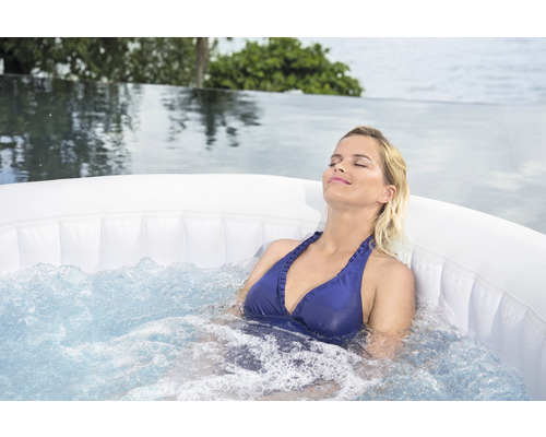 Vrouw ontspant in opblaasbare bubbelbad buiten.