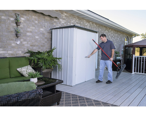 Man opent metalen gereedschapsschuur op een terras