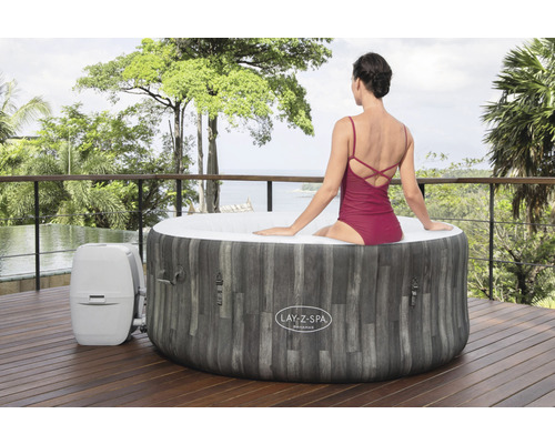 Lay-Z-Spa Bahamas op een houten terras met een vrouw in badpak en uitzicht op de natuur