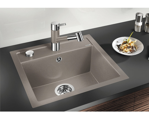 Spoelbak met kraan en bord met eten op een aanrecht