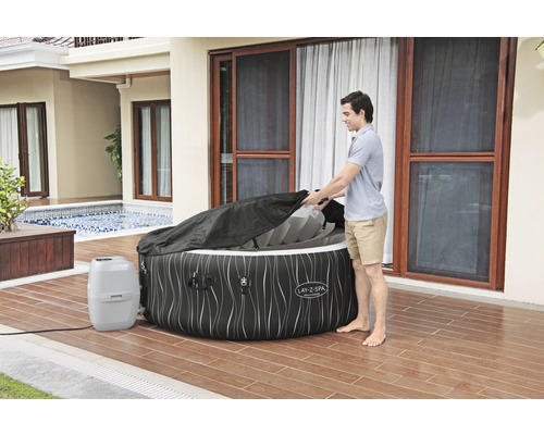 Opblaasbare Lay-Z-Spa bubbelbad met afdekking en man in de tuin
