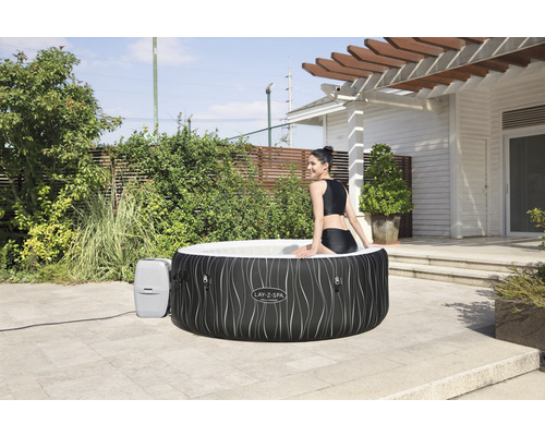 Opblaasbare Lay-Z-Spa bubbelbad in de tuin met vrouw in het water.