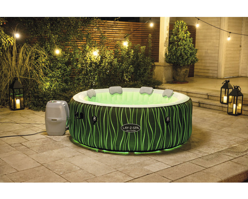 Opblaasbare hot tub met verlichting in de tuin ''s nachts.