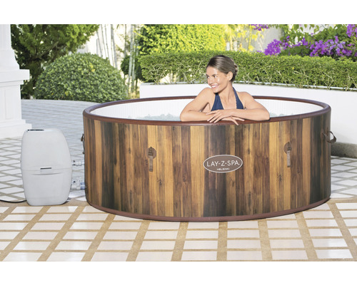 Lay-Z-Spa Helsinki bubbelbad met houtlook en grijze bedieningseenheid in de tuin met vrouw