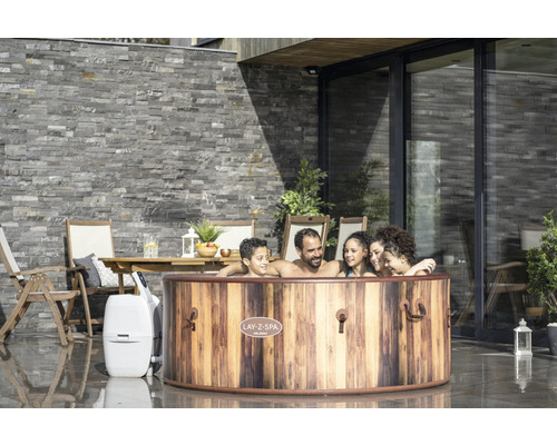 Familie ontspant in de Lay-Z-Spa Helsinki whirlpool in de tuin.