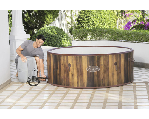 Man sluit een Lay-Z-Spa opblaasbare whirlpool aan op een pomp