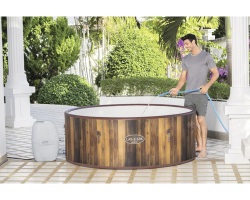 Opblaasbare Lay-Z-Spa bubbelbad met houtlook en man met waterslang