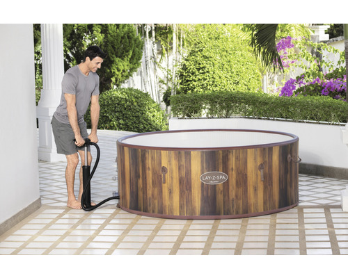 Man pompt opblaasbare Lay-Z-Spa whirlpool op in de buitenlucht