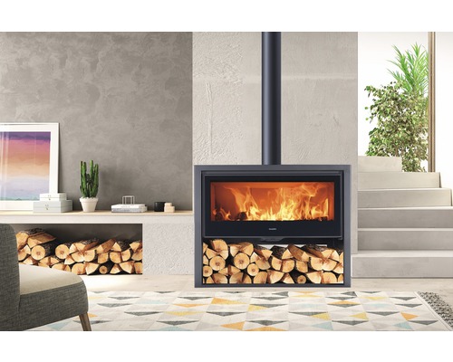 Houtkachel met brandend vuur en houtblokken in de woonkamer