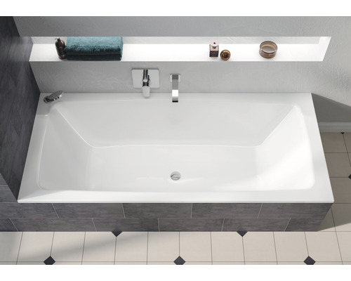 Rechthoekig bad in badkamer met kranen en opbergplank