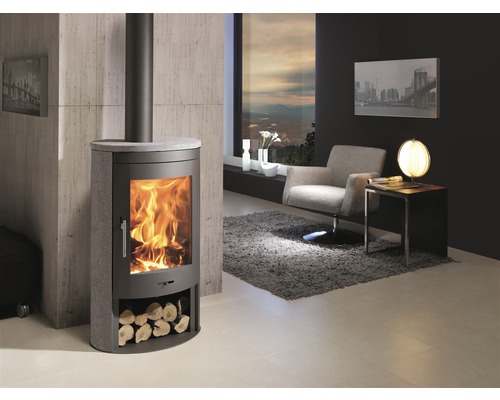 Woonkamer met kachel, fauteuil en raam