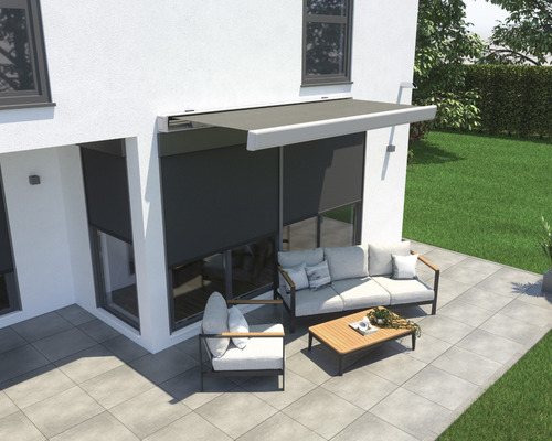 Terras met zonnescherm, zithoek en bestrating voor een huis
