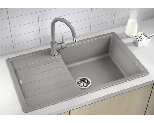 Grijze gootsteen met afdruiprek en kraan