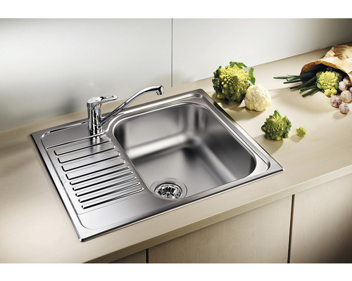 Roestvrijstalen spoelbak met afdruiprek en kraan op een aanrecht.