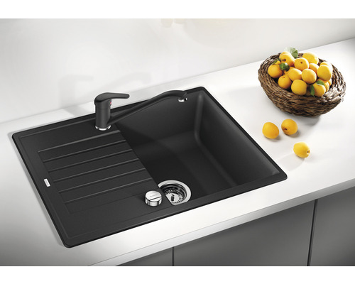 Zwarte gootsteen met afdruiprek en kraan op een aanrechtblad