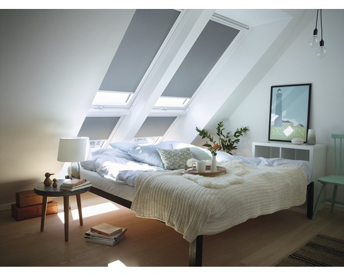 Slaapkamer met dakramen en rolgordijnen voor verduistering