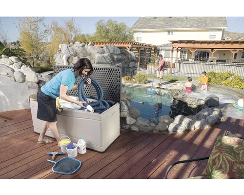 "Buitenscène met een vrouw die een opbergbox voor zwembadaccessoires vult op een houten terras bij het zwembad