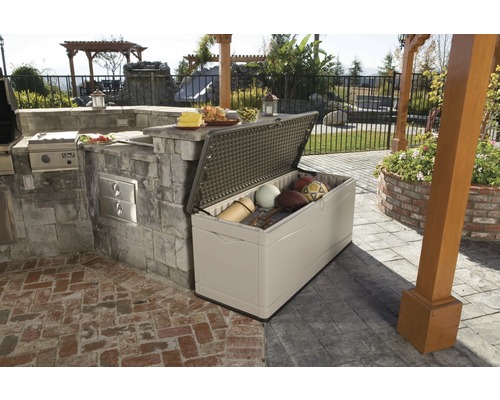 Open opbergbox buiten naast een buitenkeuken op een terras met sportartikelen erin