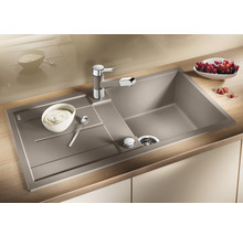 Spoelbak met afdruiprek, keukenkraan en etenswaren op een aanrecht.