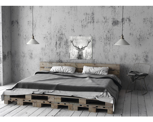 Bed van houten pallets met matras, kussens en hertenfoto