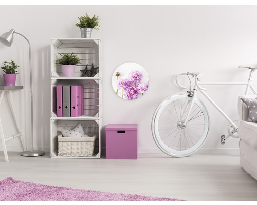 Decoratieve woonkameropstelling met witte meubels en een wanddecoratie met bloemmotief.