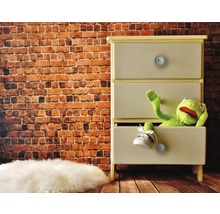 Dressoir met drie lades, een stoffen pop en een schoen voor een bakstenen muur