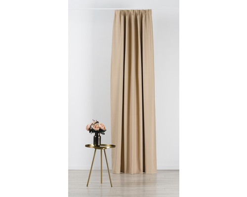 Beige gordijn hangt aan een roede, ernaast een tafel met bloemen