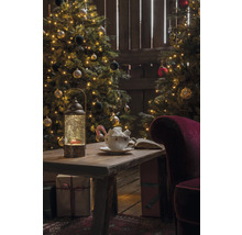 Kerstscène met versierde kerstbomen, tafel met lantaarn, kopje en cadeaus