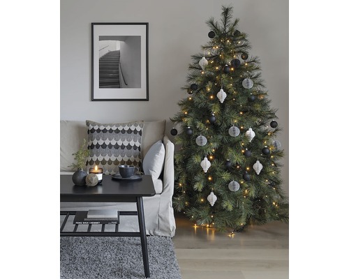 Decoratieve woonkamer met kerstboom, bank, tafel en ingelijste foto