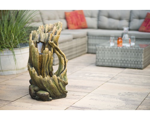 Decoratieve tuinfontein imiteert een boomstronk met water effect op terras