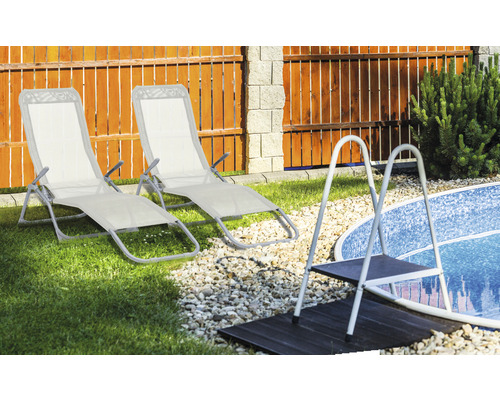 Scene met twee tuinstoelen en een zwembadladder in de tuin