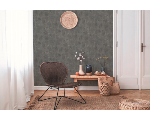 Woonkamer met rotan stoel, decoratieve wand en houten vloer