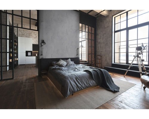 Lichte slaapkamer in loftstijl met bed, groot raam en houten vloer