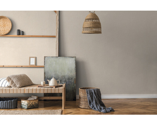 Woonkamer met lichte textielbehang, zitgelegenheid en decoratieve elementen