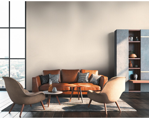 Woonkamer met leren bank, fauteuils, salontafels, boekenplank en raam