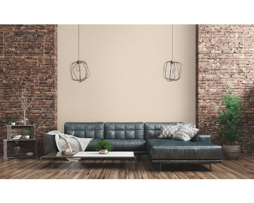 Woonkamer met leren bank, salontafel, houten plank en bakstenen muur