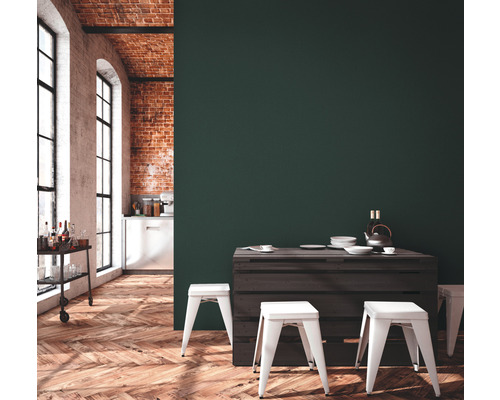 Eetkamer met houten tafel, witte krukken en bakstenen muur