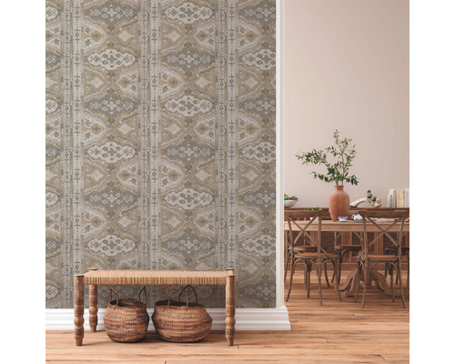 Woonkamer met behangmotief, houten bank en eethoek met houten tafel en stoelen.