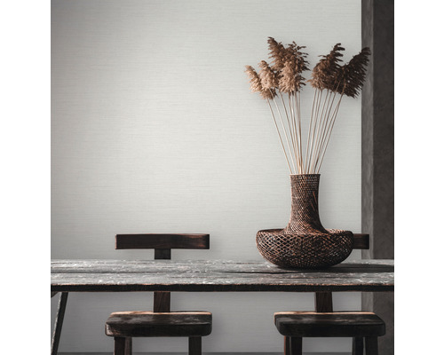 Licht, gestructureerd behang in de eetkamer met houten tafel en decoratie