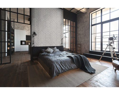 Lichte slaapkamer met bed, vloerkleed en groot raam in loftstijl