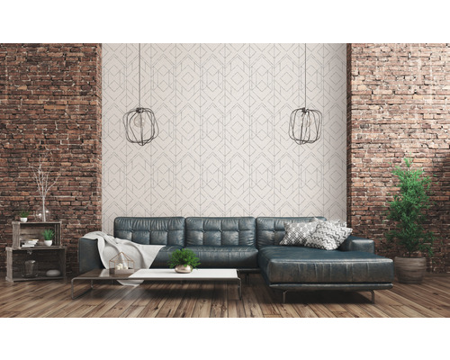 Woonkamer met leren bank, bakstenen muur en geometrisch behang