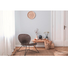 Woonkamer met rotan stoel, houten bijzettafel en decoratie