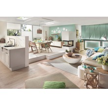 Lichte woonkamer met keuken, eethoek, open haard en bank