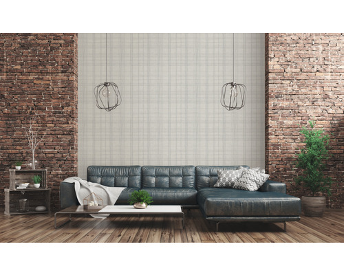 Woonkamer met leren bank, bakstenen muur en hanglampen