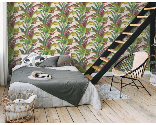 Slaapkamer met bed, stoel en wandbehang met plantmotieven voor een natuurlijke sfeer