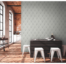 Woonkamer met patroonbehang, houten vloer en eettafel met stoelen.