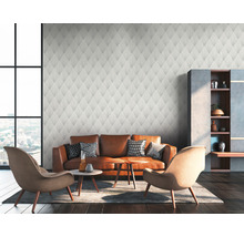 Woonkamer met patroonbehang, leren bank en fauteuils